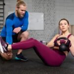 A coach helping an athlete with functional fitness training.
